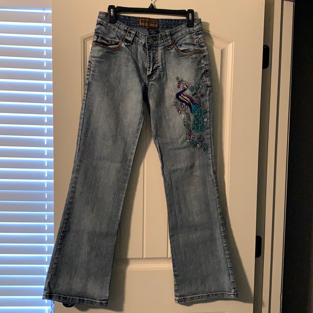 Acid wash jeans with peacock embellishments